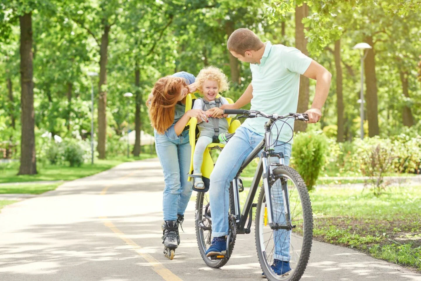 Frau (Mutter?) mit dem Fahrrad mit Kind sitzen halten