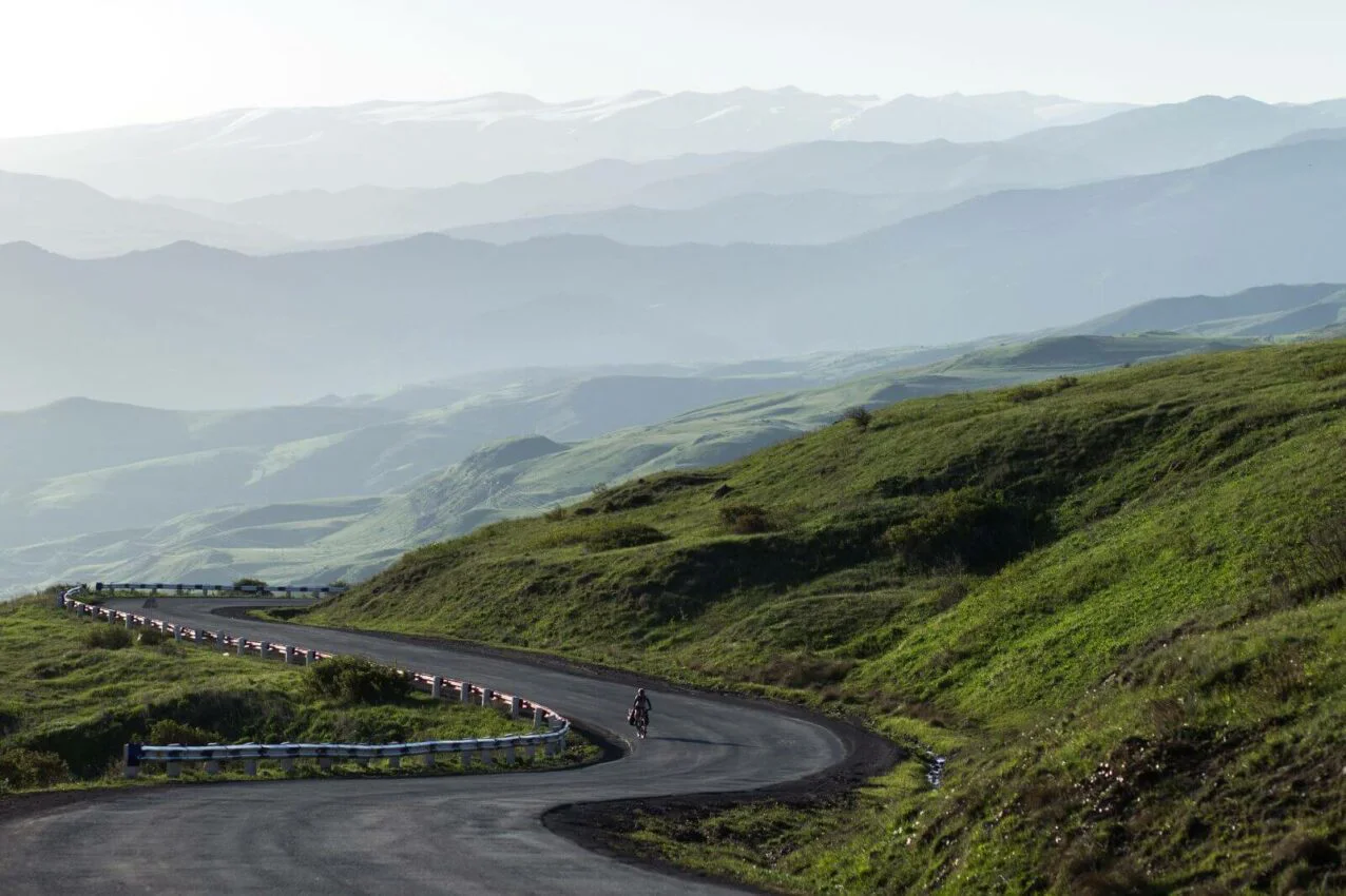 Le mythe de l’entraînement basique et autres erreurs du cycliste hivernal empty road and silhouettes of mountains in the mis